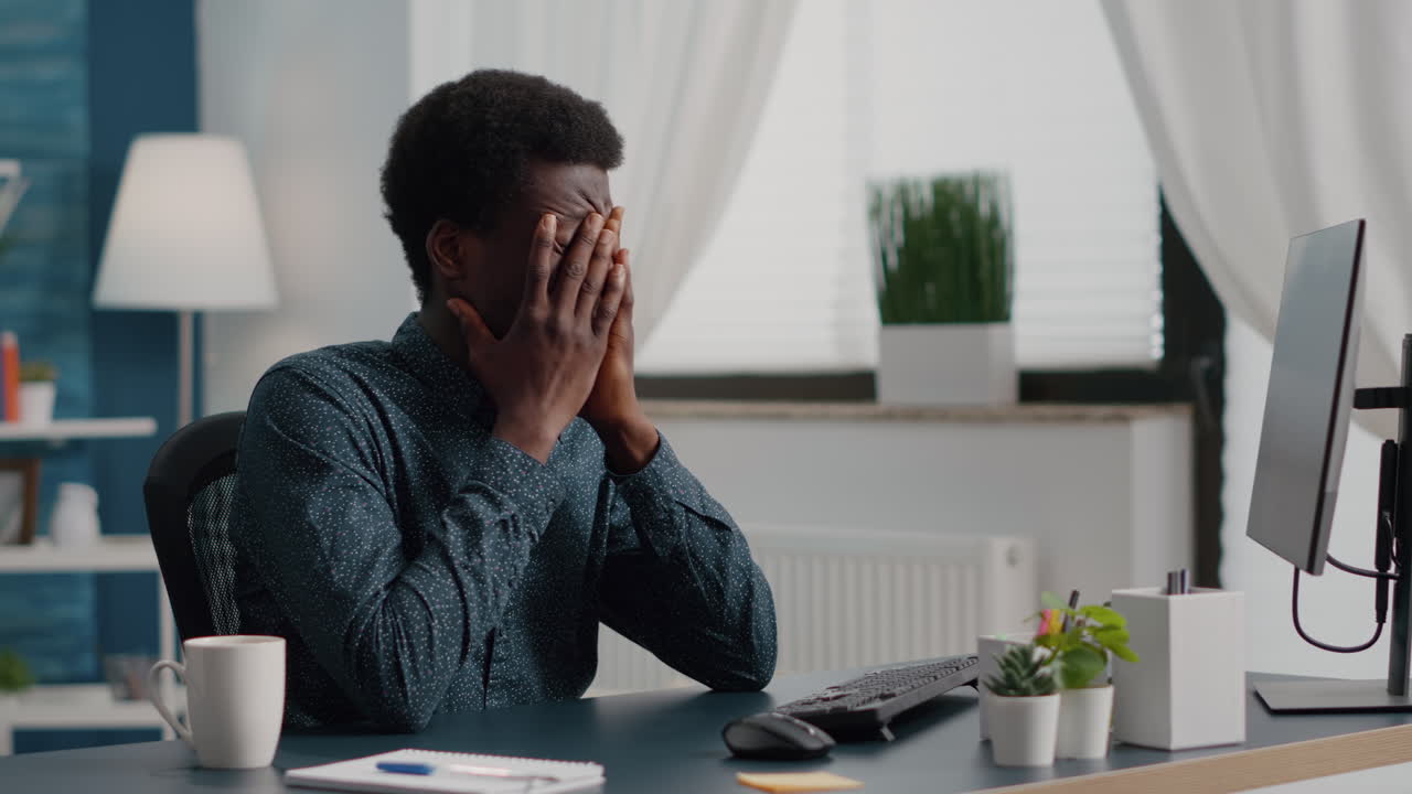 Stressing african american man with big headache pain, suffering from migraine, rubbing his temples