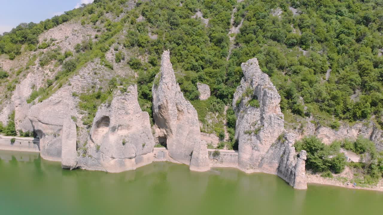 параллаксные аэрофотосъемки красивых скал с дорожными туннелями в окружении озера