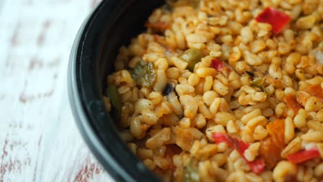 bulgur with vegetables in a black container