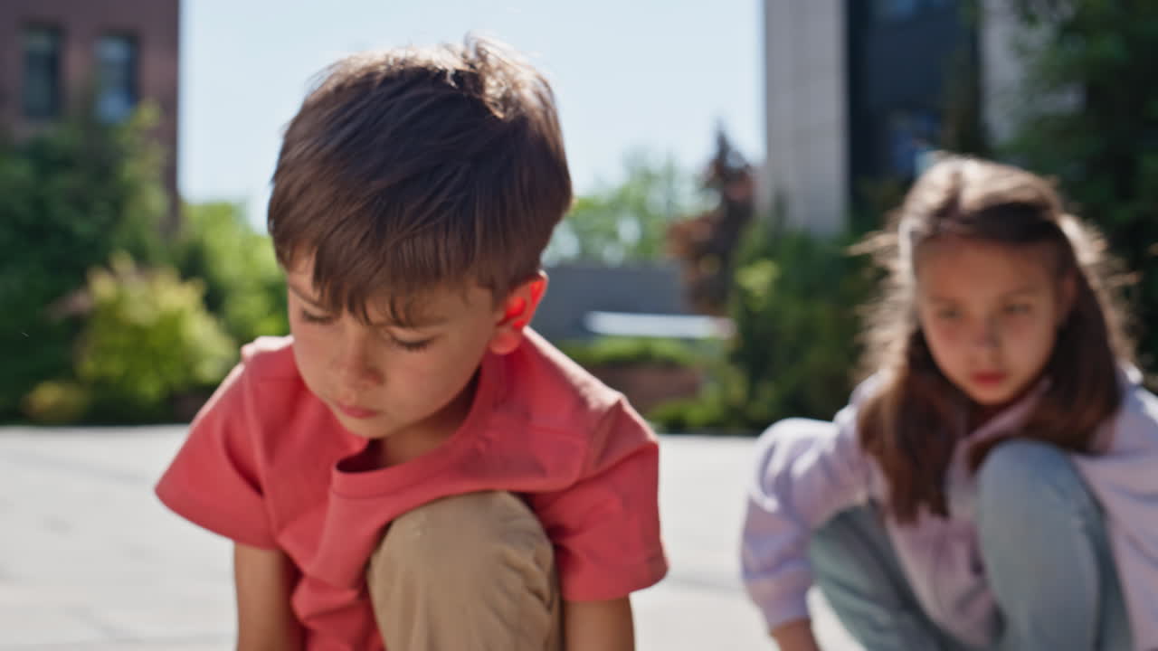 Little children drawing crayons at sunny playground closeup. Friends playing