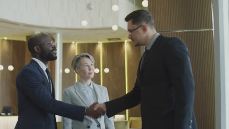 business team shaking hands and speaking in hotel