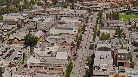 banff ab canada aerial v38 zoom shot drone flyover town center capturing the main thoroughfare banff avenue and quaint townscape on the riverside of bow river - shot with mavic 3 pro cine - july 2023