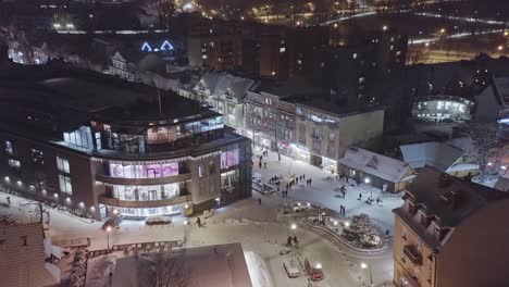 Aerial-forward-over-Zakopane-Krupowki-district-in-wintertime-at-night-with-snow-on-streets