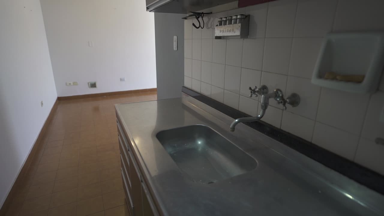 Functional Minimalist Kitchen Interior, Stainless Steel Countertops and Tiled Backsplash in a Bright Spacious Modern Apartment Environment Highlights Practicality Clean Aesthetics, slow motion reveal