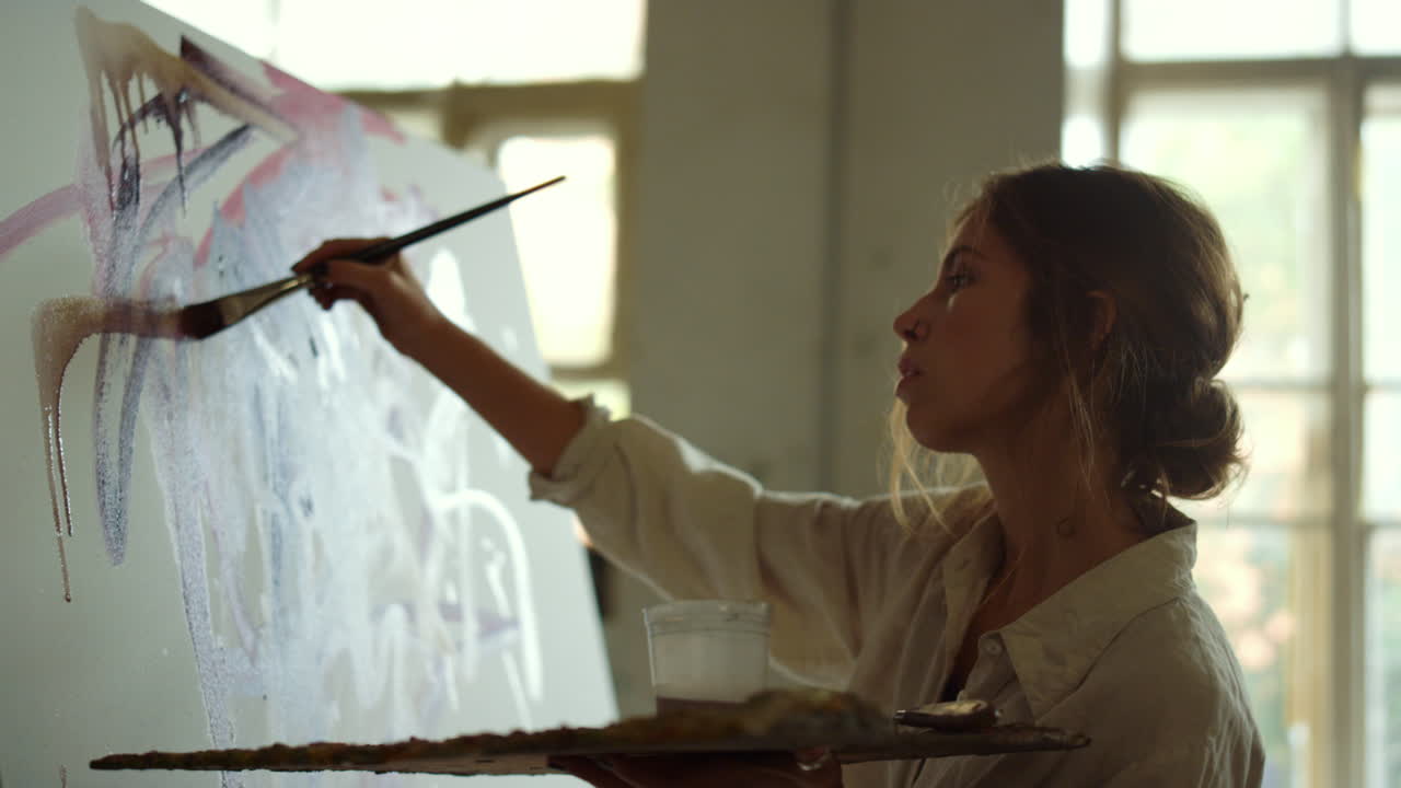 Donna creativa che crea opere d'arte in interni. Pittrice di talento che disegna in uno studio d'arte.
