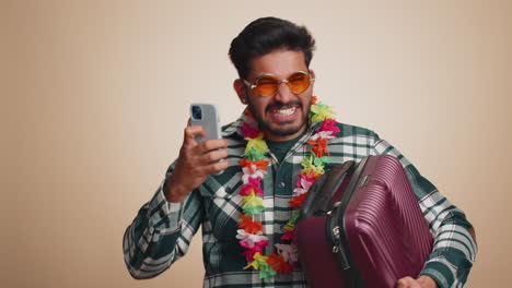 Happy-tourist-indian-man-celebrate-winning-holiday-resort-vacation-tickets-pass-online-on-smartphone