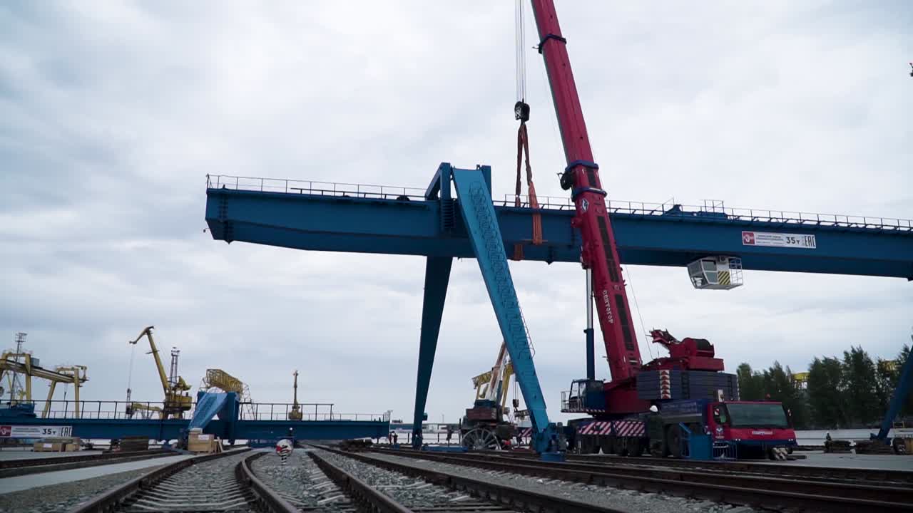 Gantry Crane Lifting a Large Metal Beam at a Port Construction Site