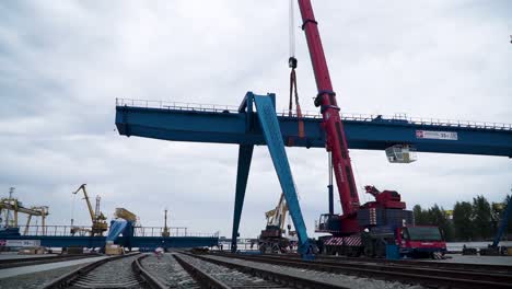 gantry crane lifting a large metal beam at a port construction site