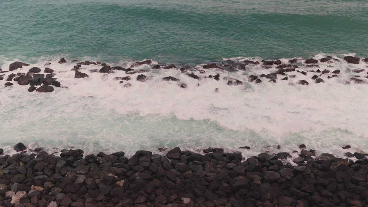 las olas del océano chocando contra la orilla rocosa