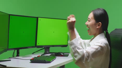 컴퓨터 녹색 화면 앞에서 축하하는 여자
