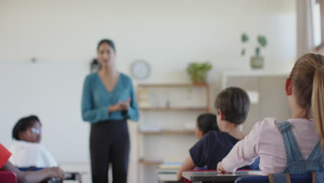 in school, teacher engaging with students sitting at desks in classroom