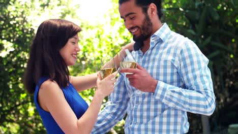 una pareja romántica sonriente brindando copas de vino