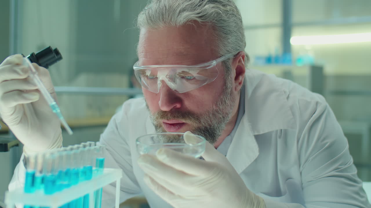 Senior Chemist Pouring Blue Chemical in Test Tubes in Lab
