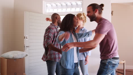 friends help couple to carry boxes into new home on moving day