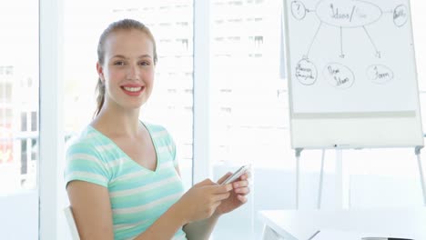 mujer de negocios casual enviando mensajes de texto en su teléfono inteligente