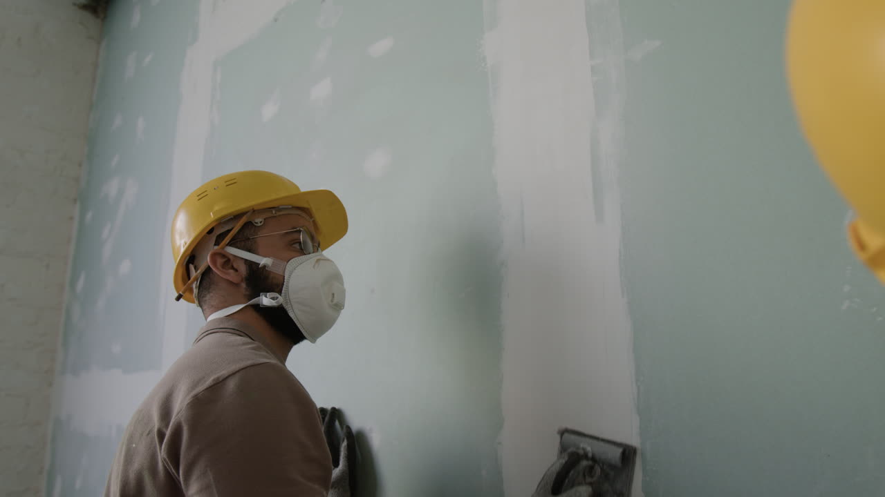 Construction worker applying plaster to wall