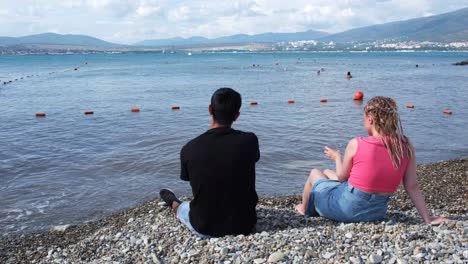 couple relaxing on a pebble beach