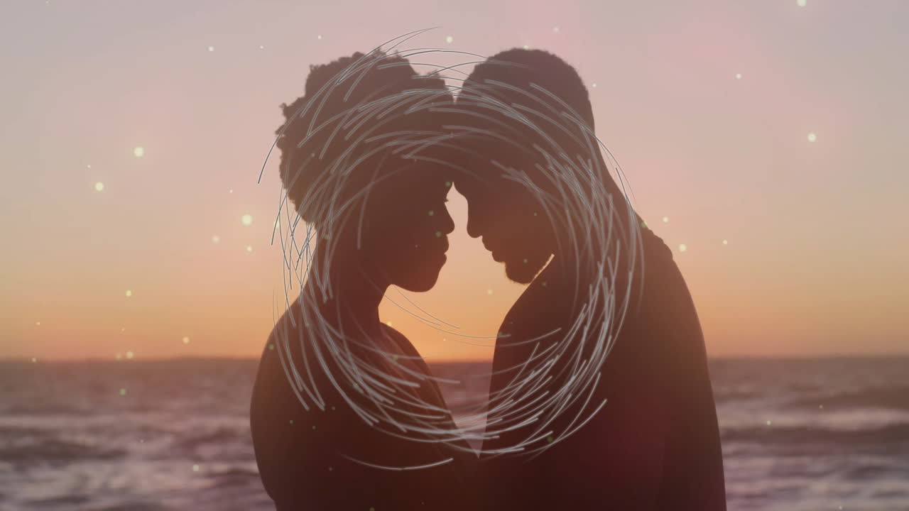 Silhouetted couple embracing at sunset with swirling light animation overlay