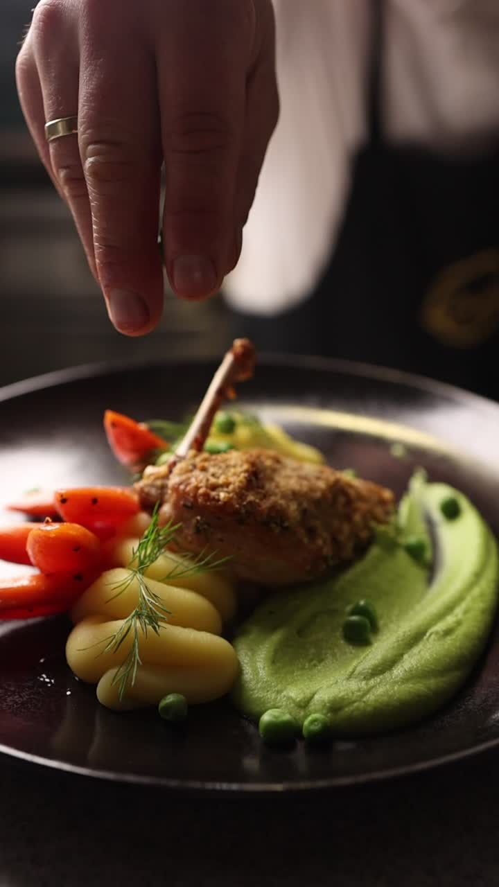 Chef che guarnisce un piatto gourmet di pollo con piselli