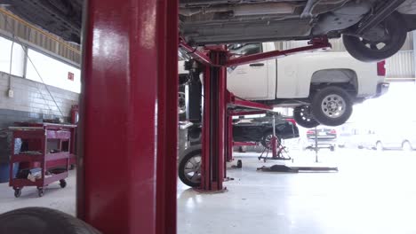 Travel-shot-of-a-Latin-male-mechanic-servicing-repairing-an-engine-from-below-the-car-at-a-workshop-station-in-Puebla-Mexico-Latin-America