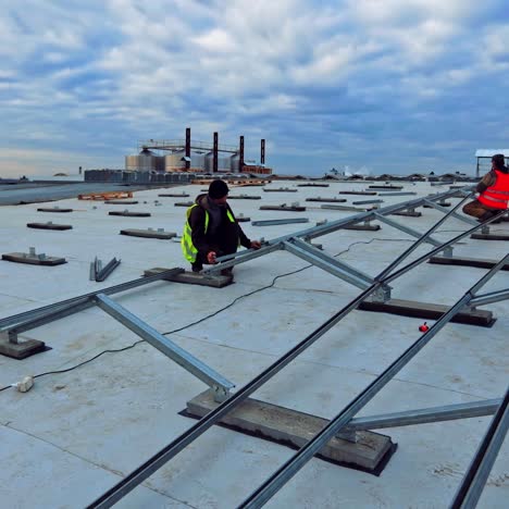 workers install metal base for solar panels. construction of new solar farm under the motion of clouds in the sky. time lapse.