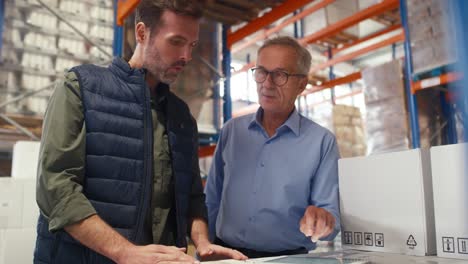 mature men working togetherness in the warehouse.