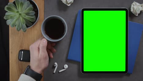 top-down view of workspace with tablet, coffee, and accessories