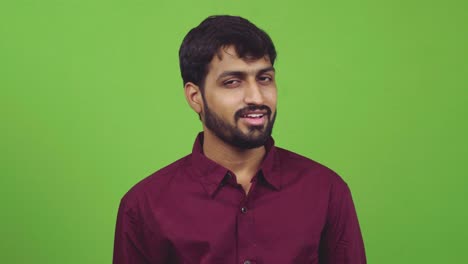 attractive man looking towards camera and gets distracted, isolated on green screen