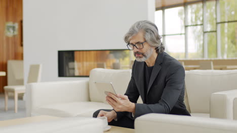 senior man with digital tablet at lounge zone