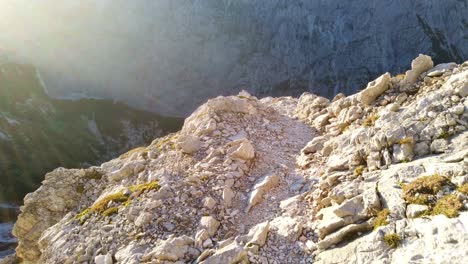 Point-of-view-of-walking-a-high-alpine-gravel-path-with-some-patches-of-green-grass