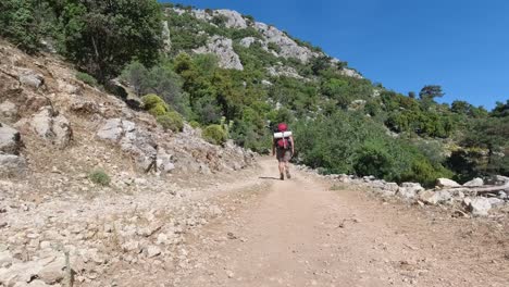 Ein-Wanderer-Geht-Weg,-Während-Er-Seinen-Rucksack-Auf-Einem-Schotterweg-In-Der-Türkei-Ausrichtet