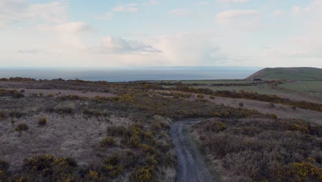 4K-Aerial-Shot-Over-North-Devon-Moor-and-Farmland-with-Sea-in-Background-and-Blue-Sky