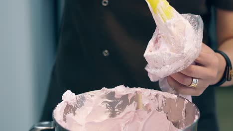 confectioner puts cream into pastry bag to decorate cake