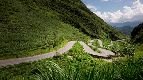 the winding mountain pass road on sunny day in ha giang loop, tham ma pass