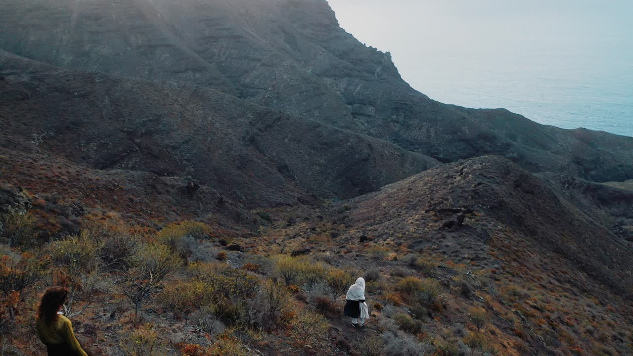 Aerial Follow Shot Of Adult Slowly Hiking Down Cliff In Canary Islands. Follow Shot