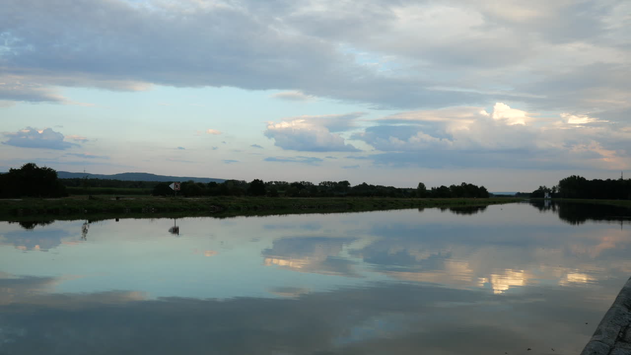 hermoso río después del atardecer con reflejo de la superficie del agua durante el atardecer en la noche en un día nublado