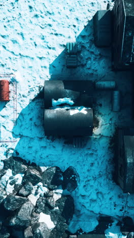 vista aérea de una zona industrial nevada con tuberías y edificios oxidados