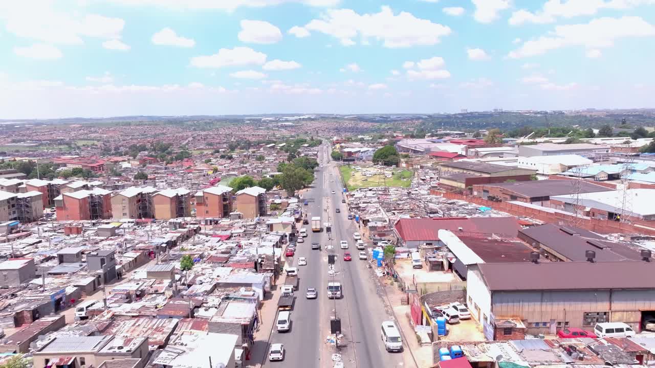 Aerial zoom in shot of informal settlement in Alexandra Township, Johannesburg, South Africa, on a sunny day with scattered clouds