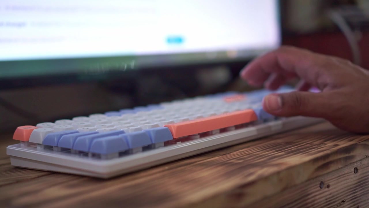 hands typing on mechanical keyboard, blurred computer screen background, work and technology typing concept.