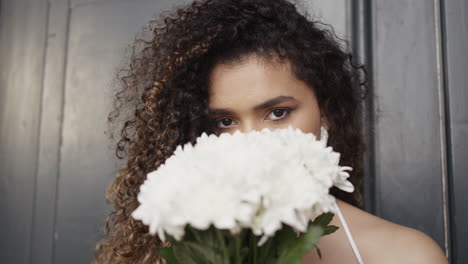 mujer de cabello rizado y flores blancas