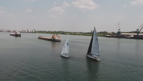 yates de vela y buques de carga en un río