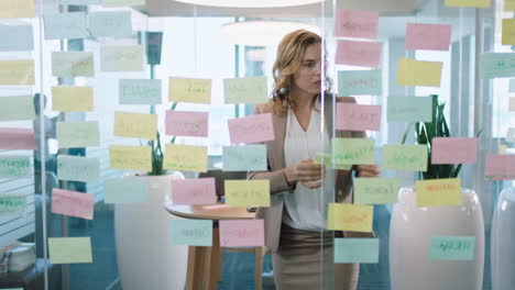 beautiful business woman using sticky notes brainstorming ideas planning strategy problem solving with creative mind map working on solution in office 4k