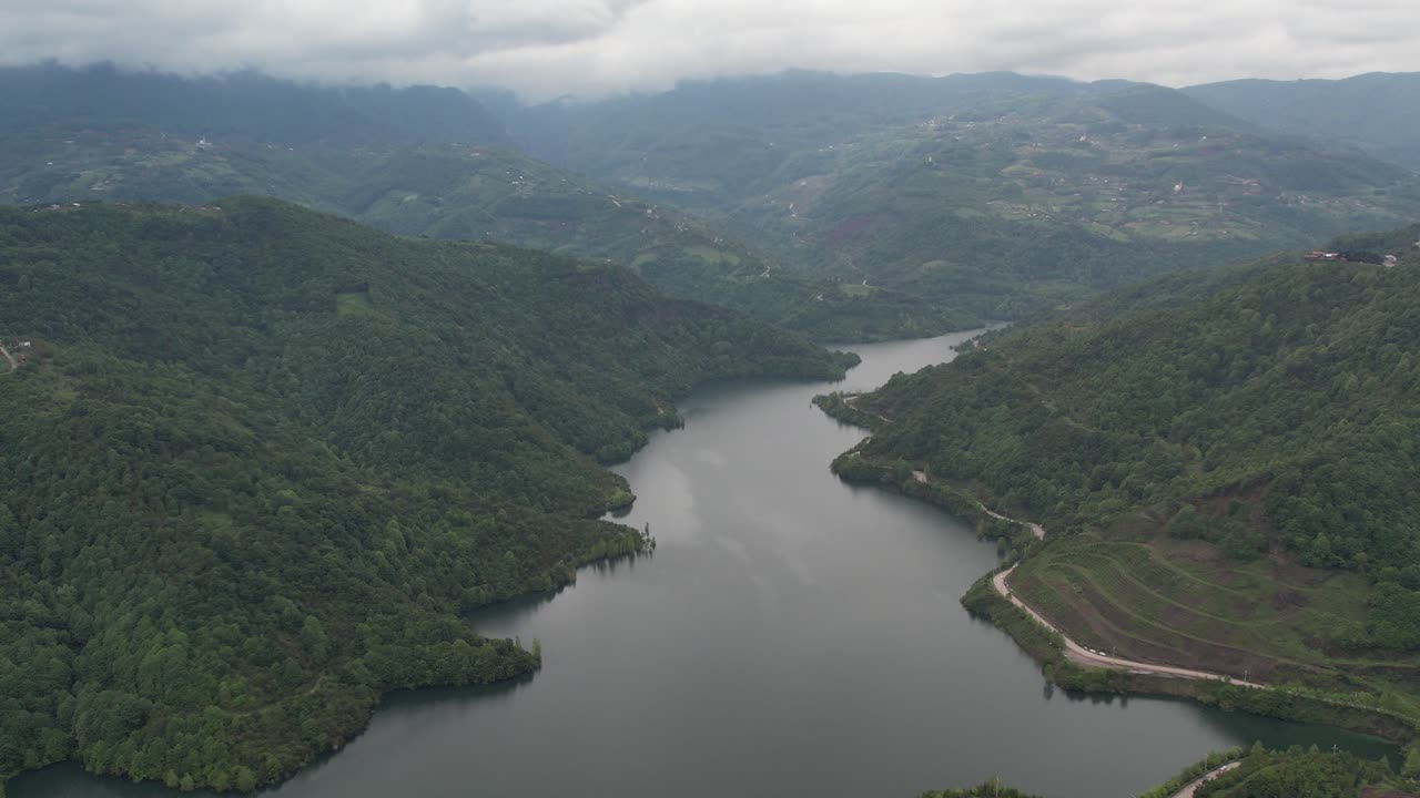드론 뷰 언덕과 산과 호수  ⁇ 의 숲, 구름진 하늘 아래의 자연 풍경