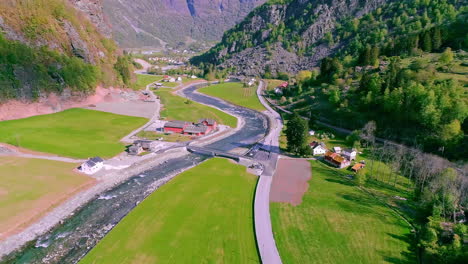 Green-valley-with-a-river-between-mountains-with-some-buildings-and-bridges