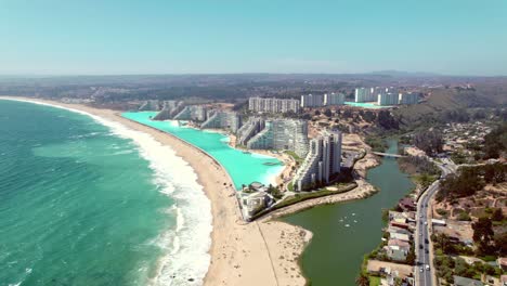 aerial establishing shot of seafront resorts looking out onto pejerrey beach in chile