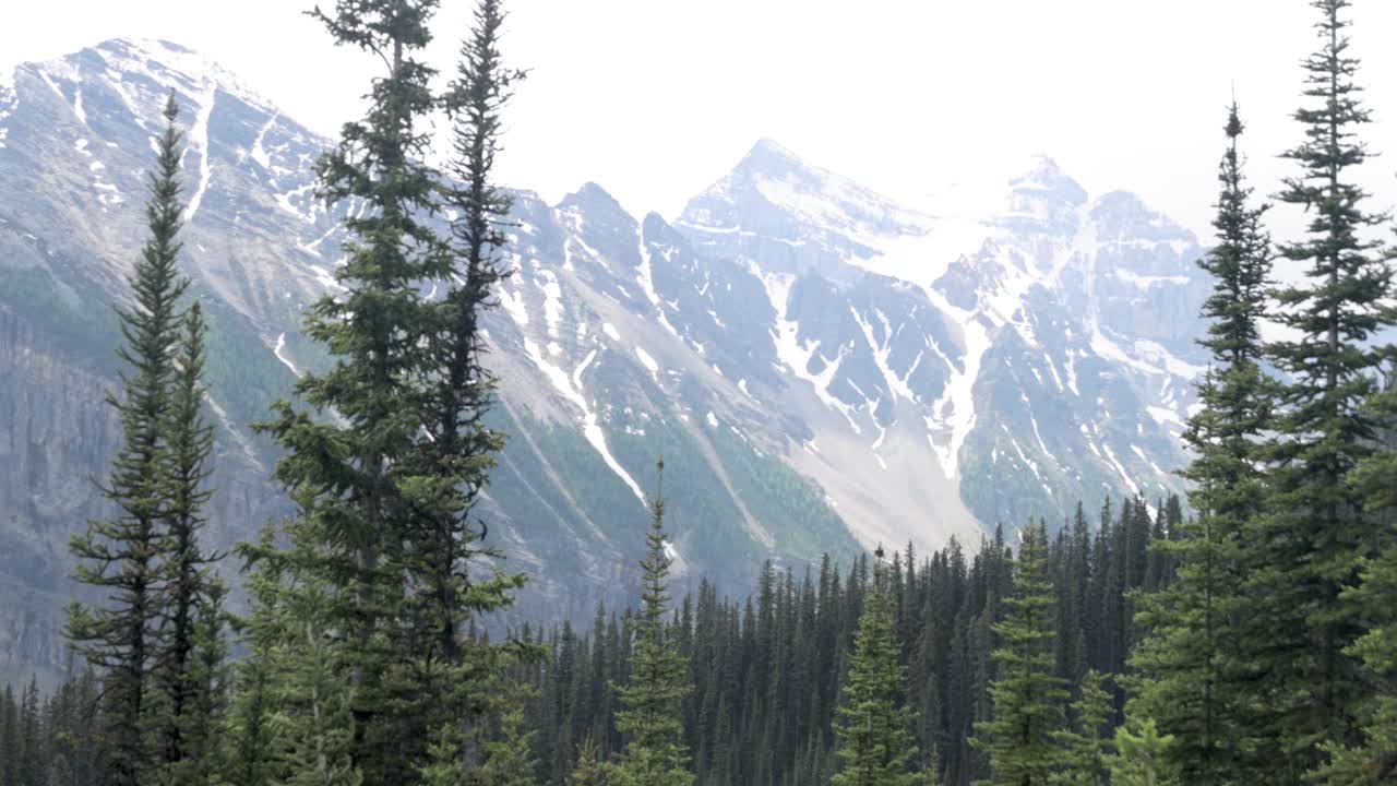 Beautiful view of a mountain range with snow on it from the hiking trail up to Lake Agnes Tea House on Mount St. Piran and Mount Whyte, within Banff National Park near Lake Louise Alberta.