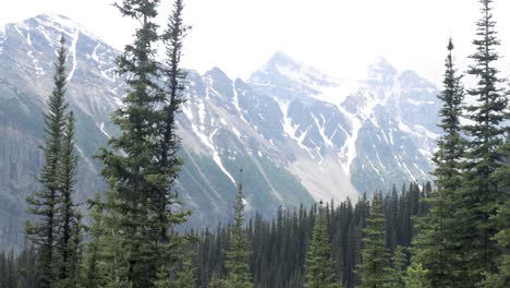 beautiful view of a mountain range with snow on it from the hiking trail up to lake agnes tea house on mount st. piran and mount whyte, within banff national park near lake louise alberta.