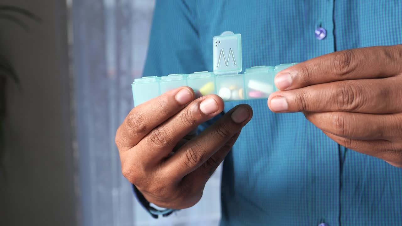 persona que utiliza un organizador de pastillas