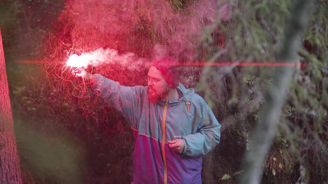 숲에서 빨간 불꽃을 들고 있는 남자