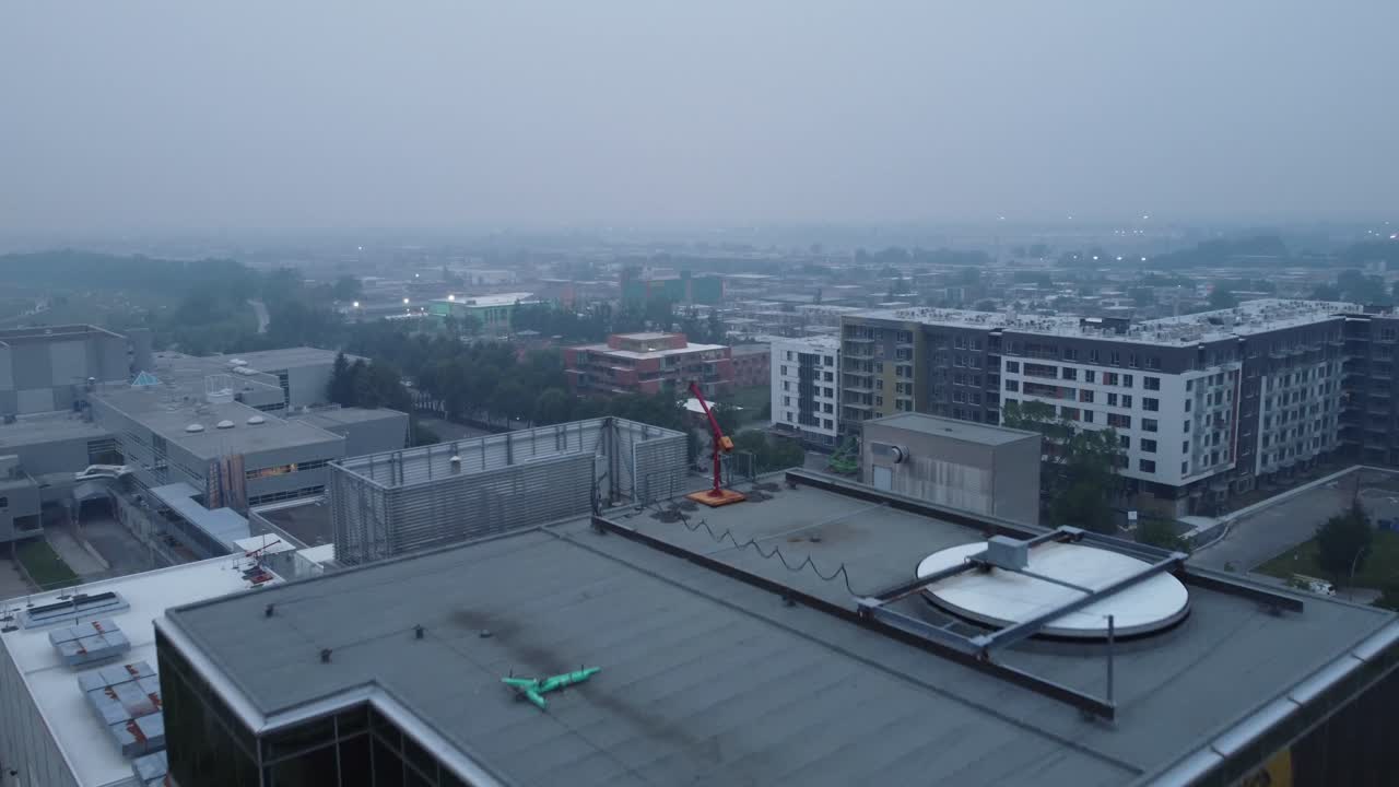 Rooftop reveal to foggy neighborhood apartment buildings in city